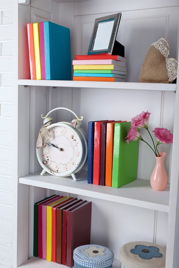 Bookshelf with colorful books and vases.