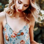 Woman wearing floral sundress with spaghetti straps.