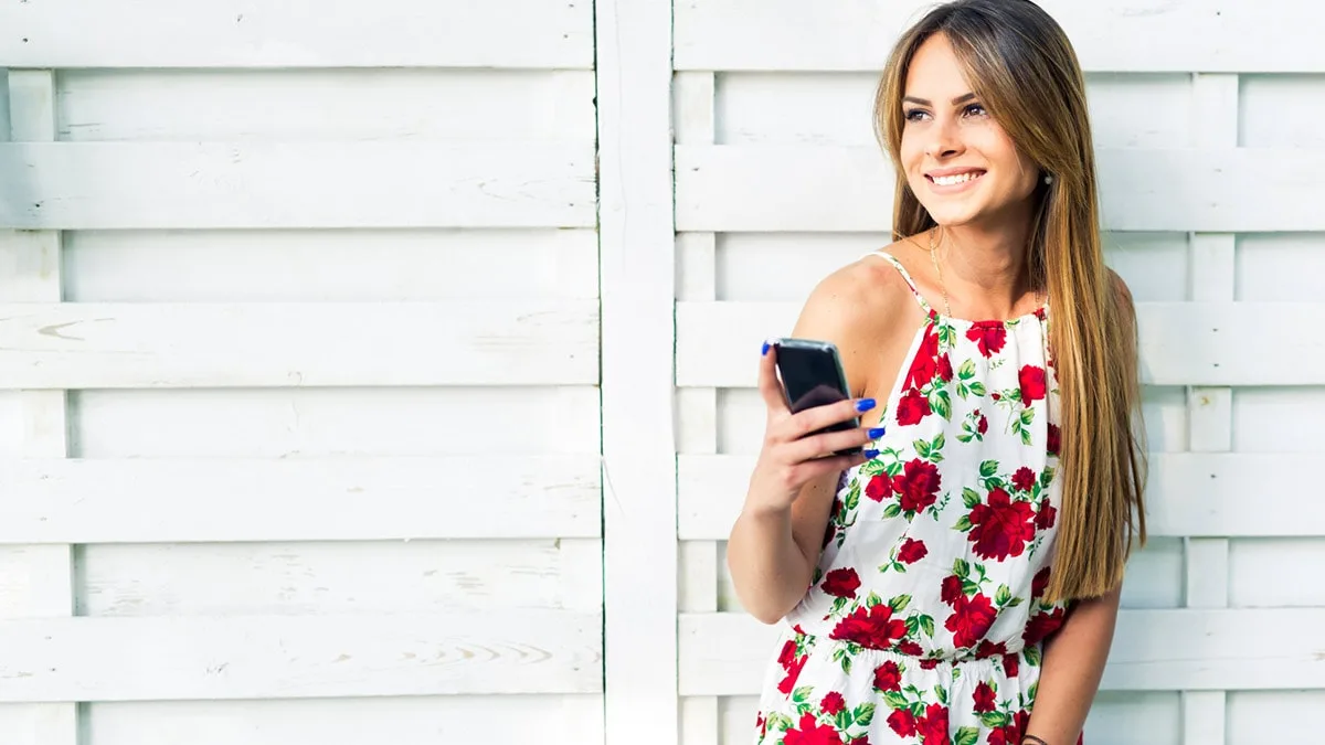 Woman wearing summer dress and holding her phone