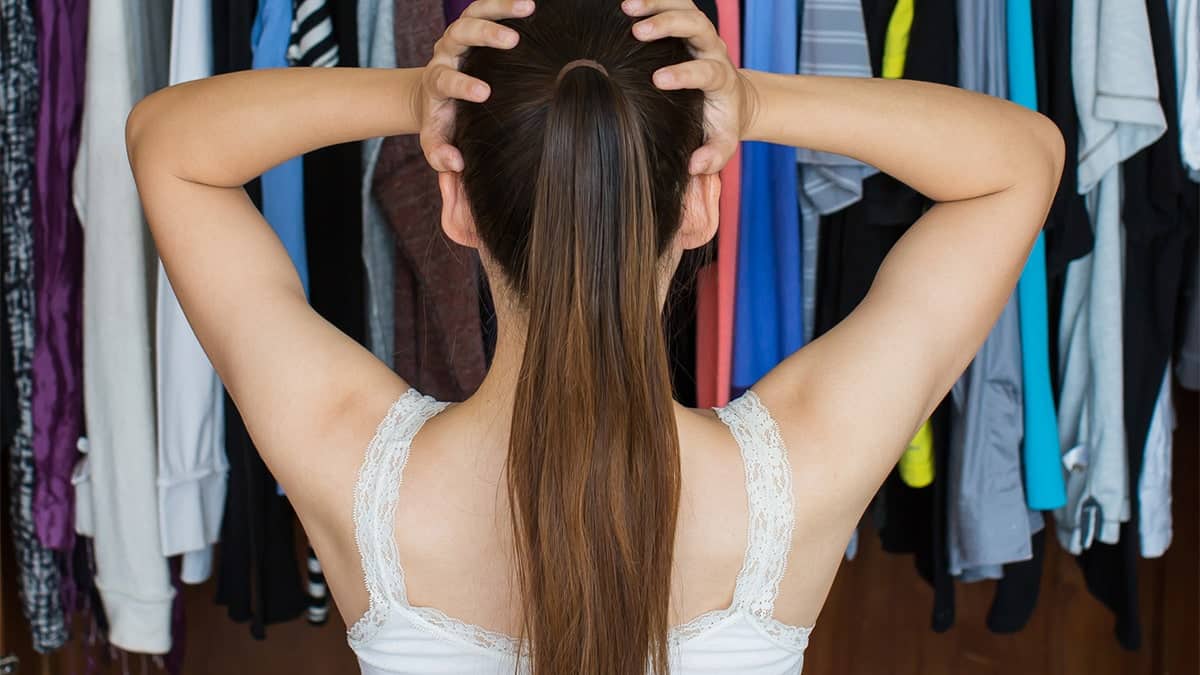 Woman staring at cluttered closet