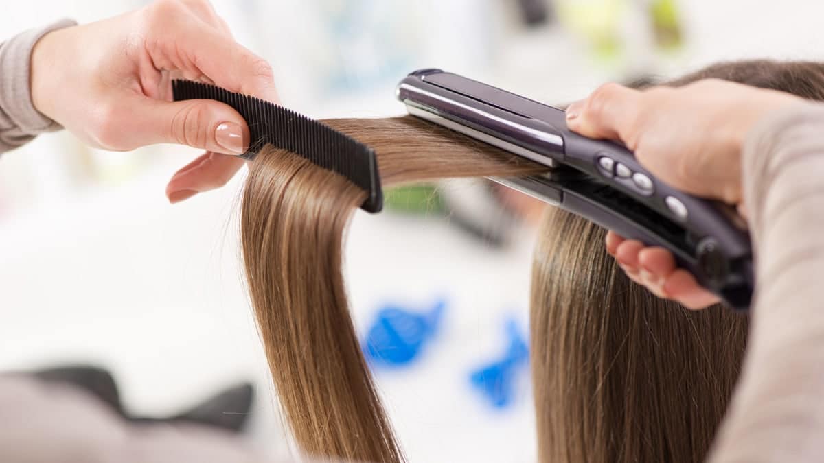 Stylist using a hair straightener