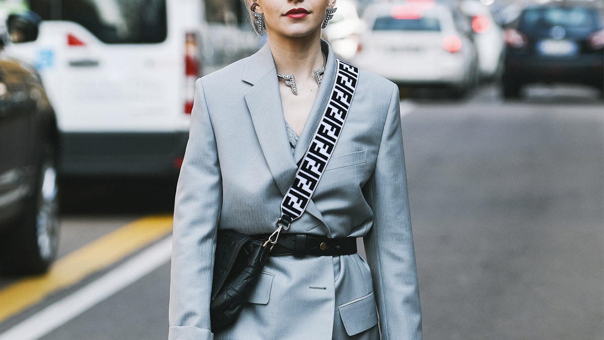 Stylish woman on street wearing crossbody bag.