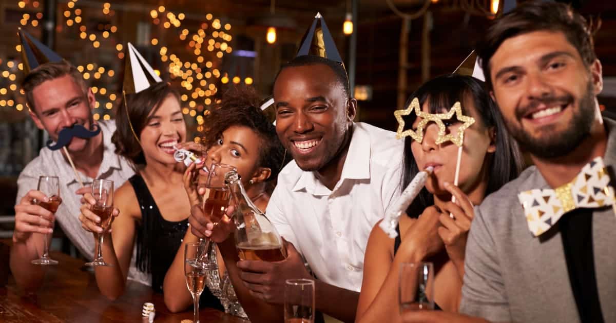 Friends celebrating wearing New Year's Eve outfits at a bar.