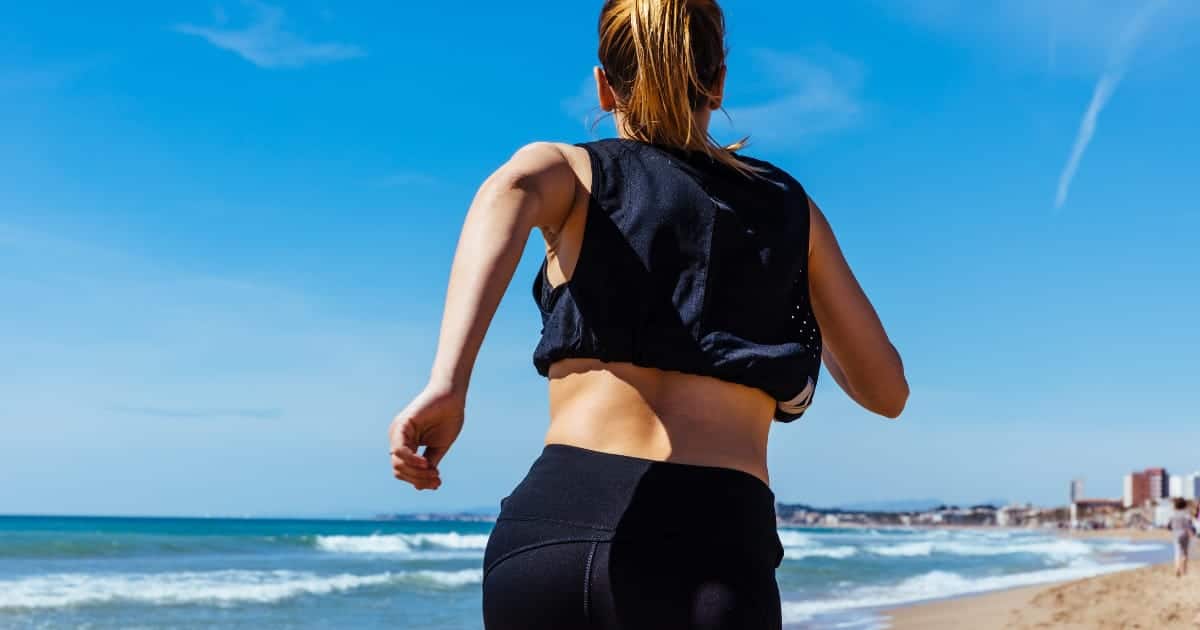 Back view of woman running outside.