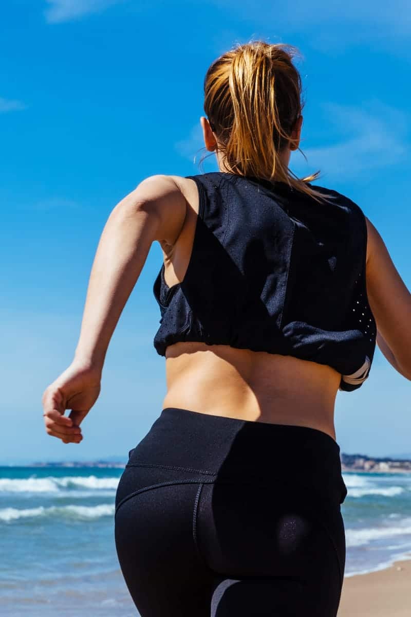 Back view of woman running outside.