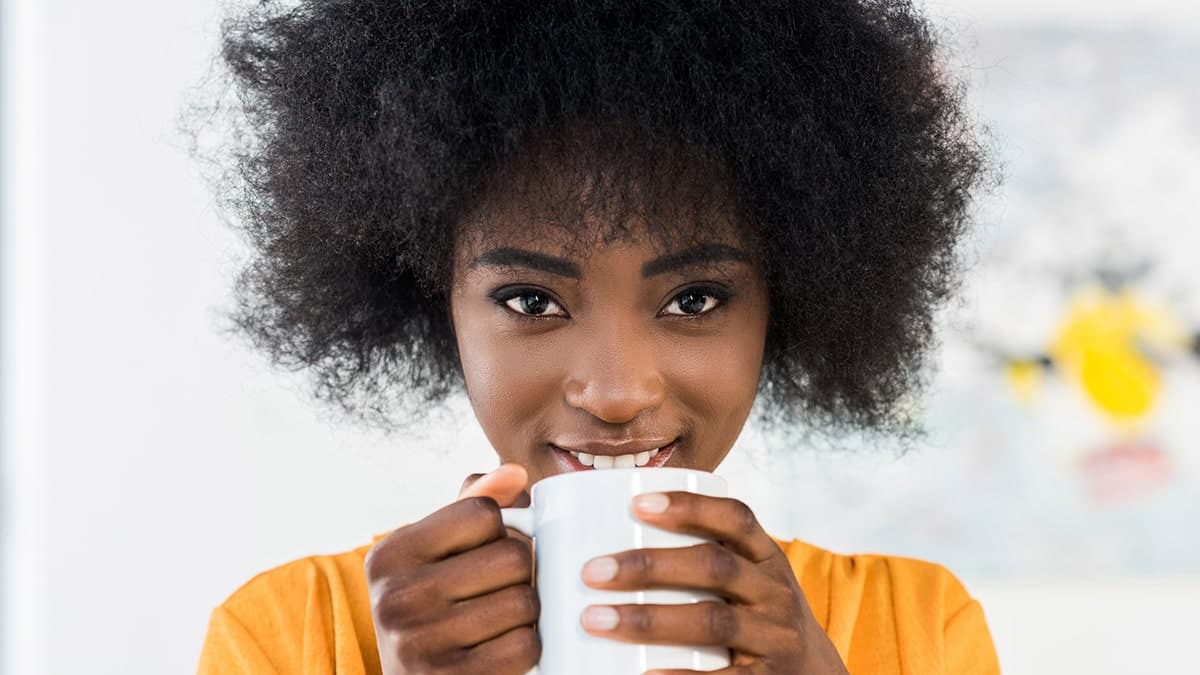 Woman drinking coffee to indulge in cheap treat