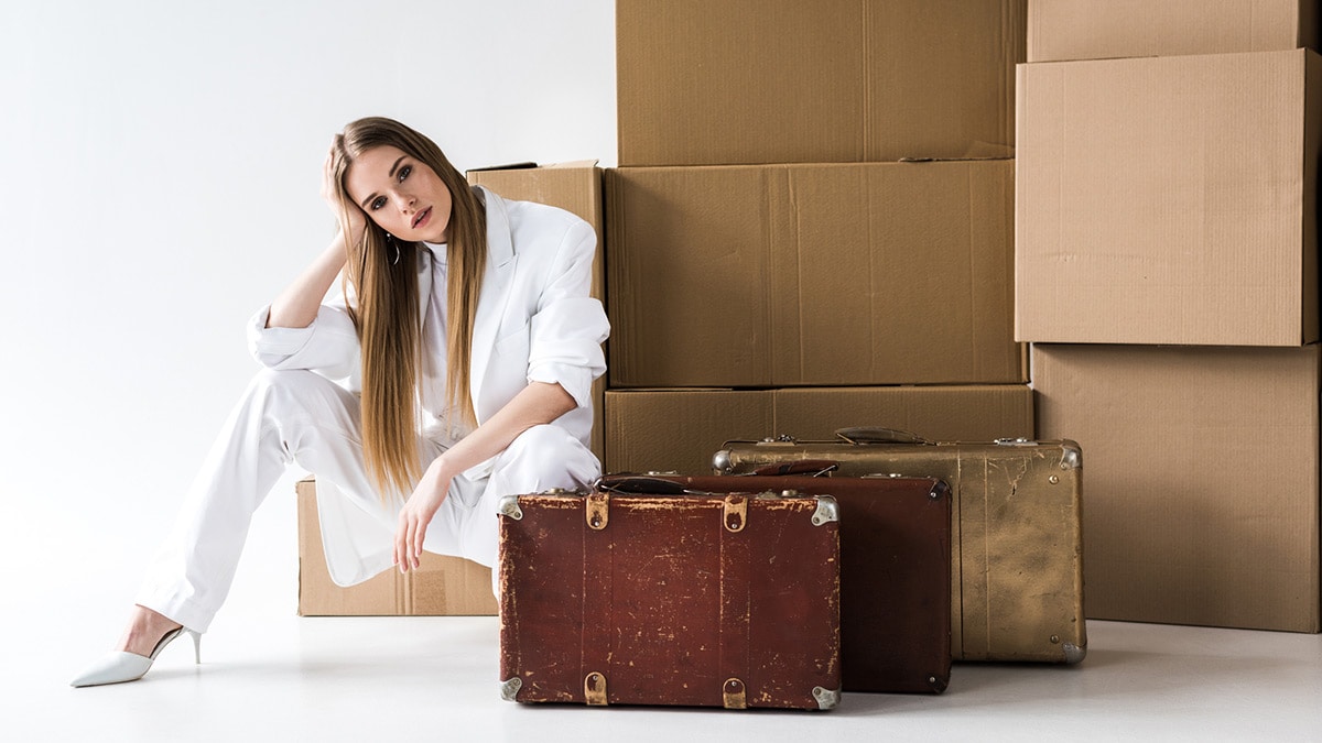 Woman sitting in front of boxes and suitcases