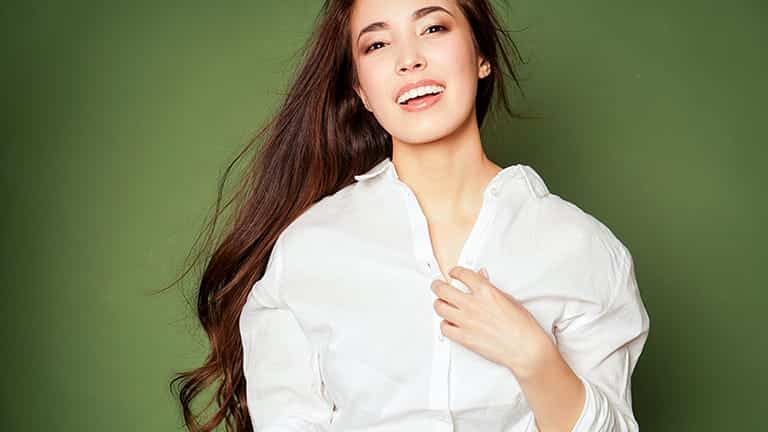 Smiling woman wearing oversized top.