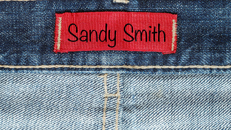 How To: Labeling Clothing for Daycare, School, and More 1 Close-up of clothing label with name written on it to represent labeling clothing.