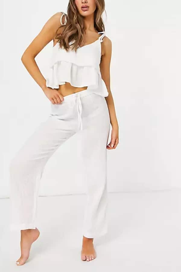 The Very Best Beach Outfits -- and How to Copy Them 1 Woman wearing white two-piece summer beach outfit.