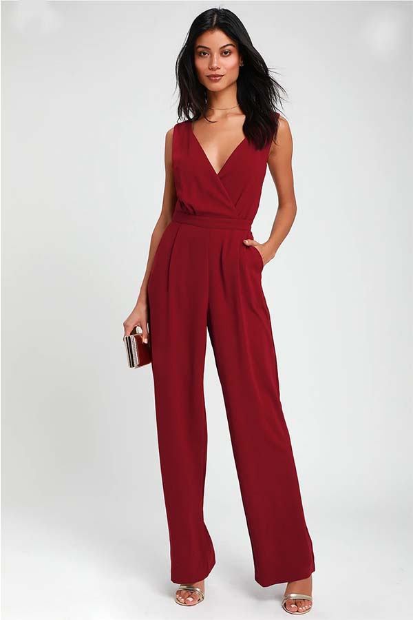 A model in a red jumpsuit with a deep V-neckline and lace trim.