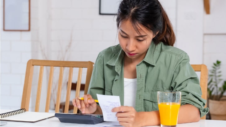 Woman works on household budget because of clothing inflation.