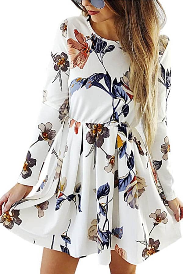 Close-up of model wearing white, long-sleeved dress with floral print.
