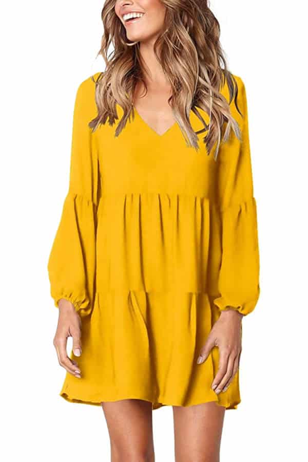 Close-up of model wearing yellow tiered dress with long sleeves.