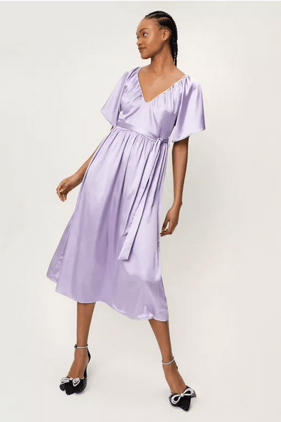Model wearing belted lavender dress with sleeves.
