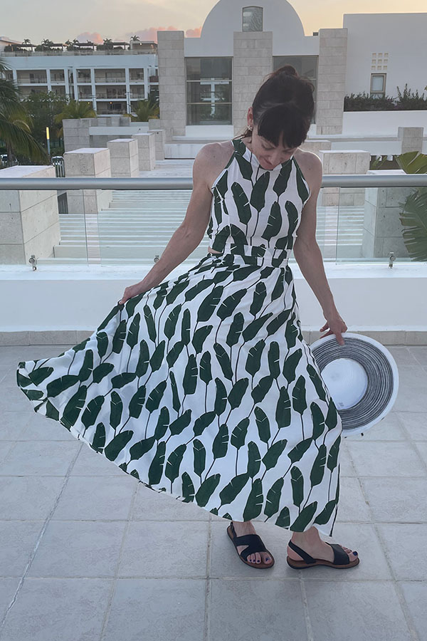 Catherine Brock twirling while wearing palm print dress from Chicwish.