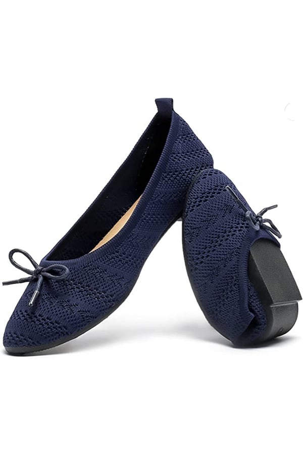 Navy blue crocheted flats on white background.
