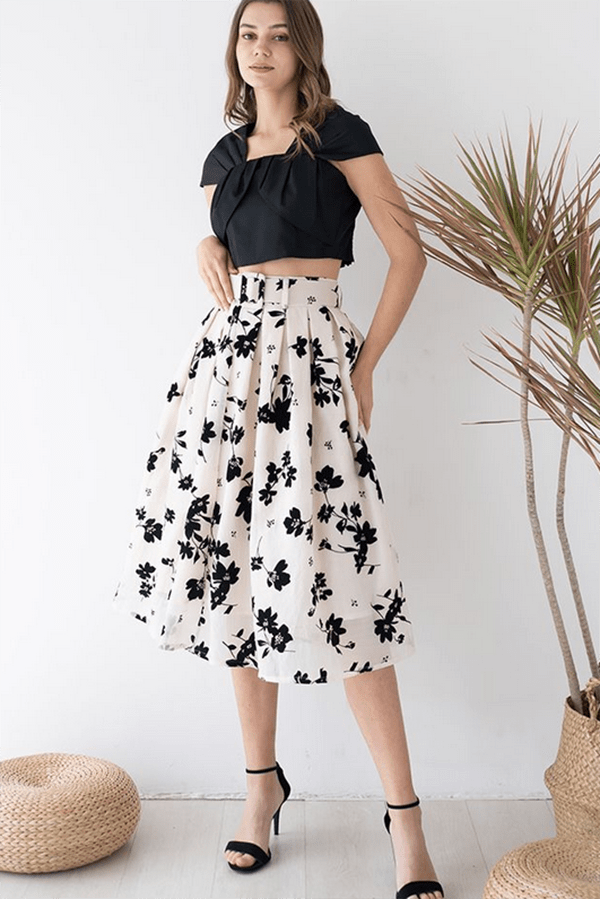 Model wearing floral summer skirt with black crop top.