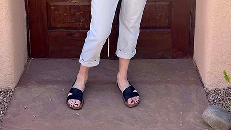 Close-up of woman's feet wearing cute black flats.