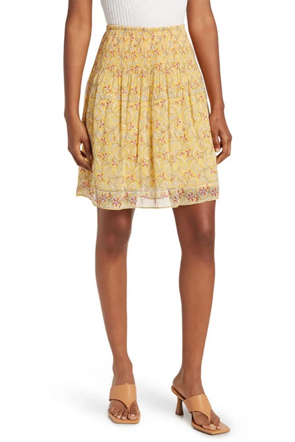 Close up of model wearing yellow patterned summer skirt.