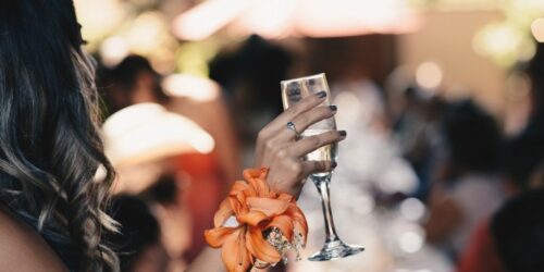 Blurred wide view of wedding guest holding champagne.