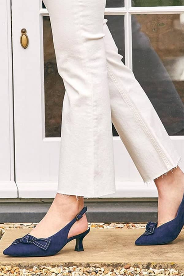 Close up of women's legs and feet, with navy blue shoes for bunions.