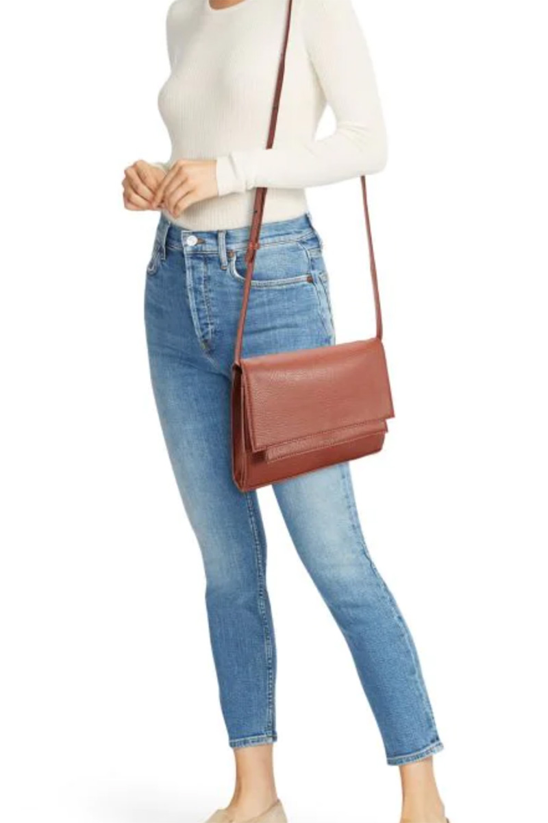 Model wearing brown leather crossbody bag.