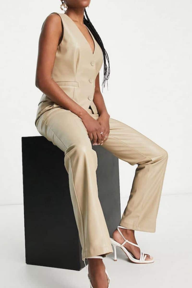 Fall Clothing Checklist: 9 Trendy Pieces You Need 11 Model wears leather-look vest and matching pants while sitting on platform.
