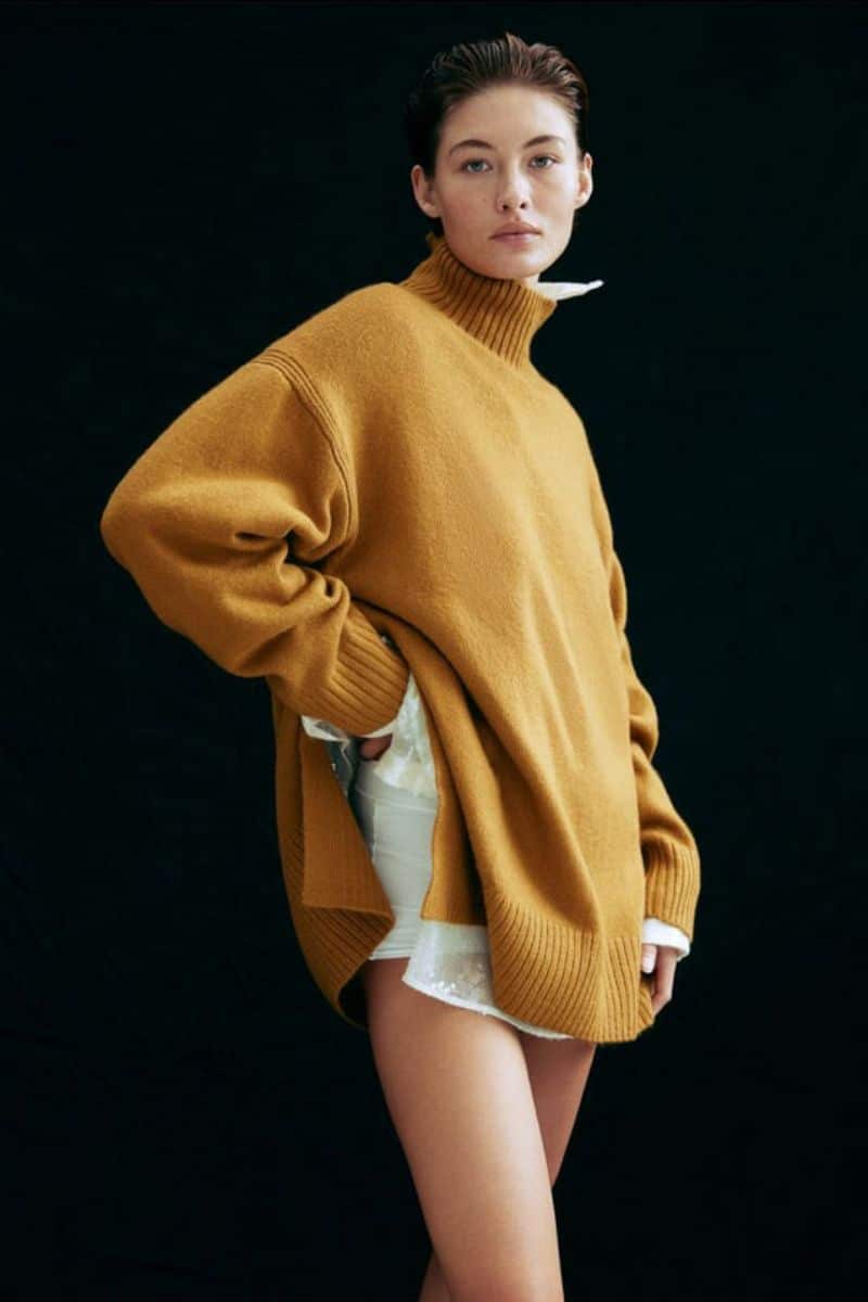 Fall Clothing Checklist: 9 Trendy Pieces You Need 5 Model wears yellow oversized turtleneck in front of black background.