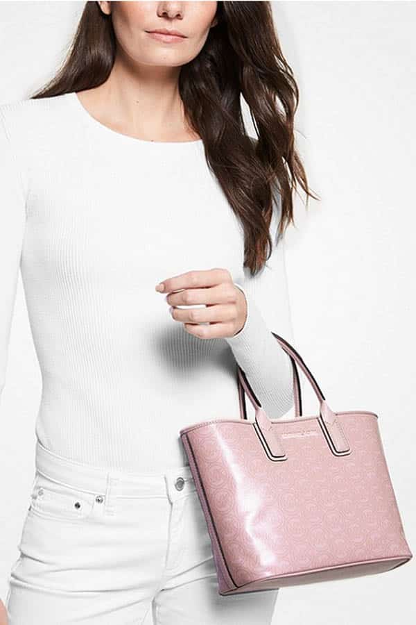 Model holds Michael Kors purse, discounted for a Labor Day sale.