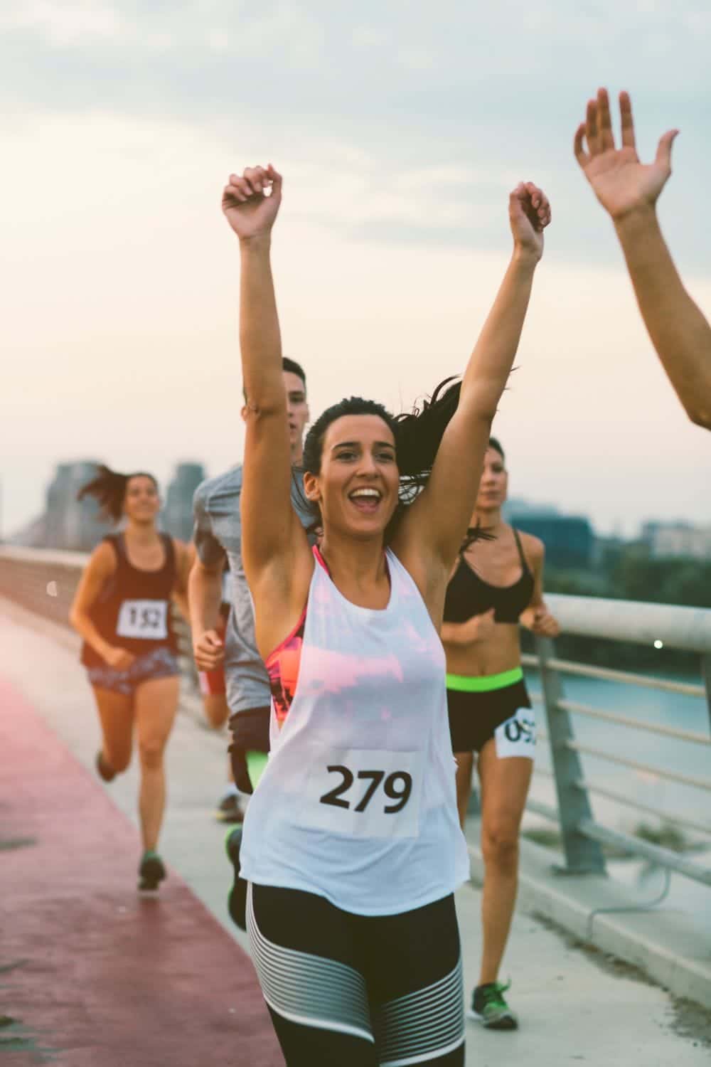 11 Brilliant Budget Halloween Costume Ideas 2 Runner in race raises arms to celebrate finish.