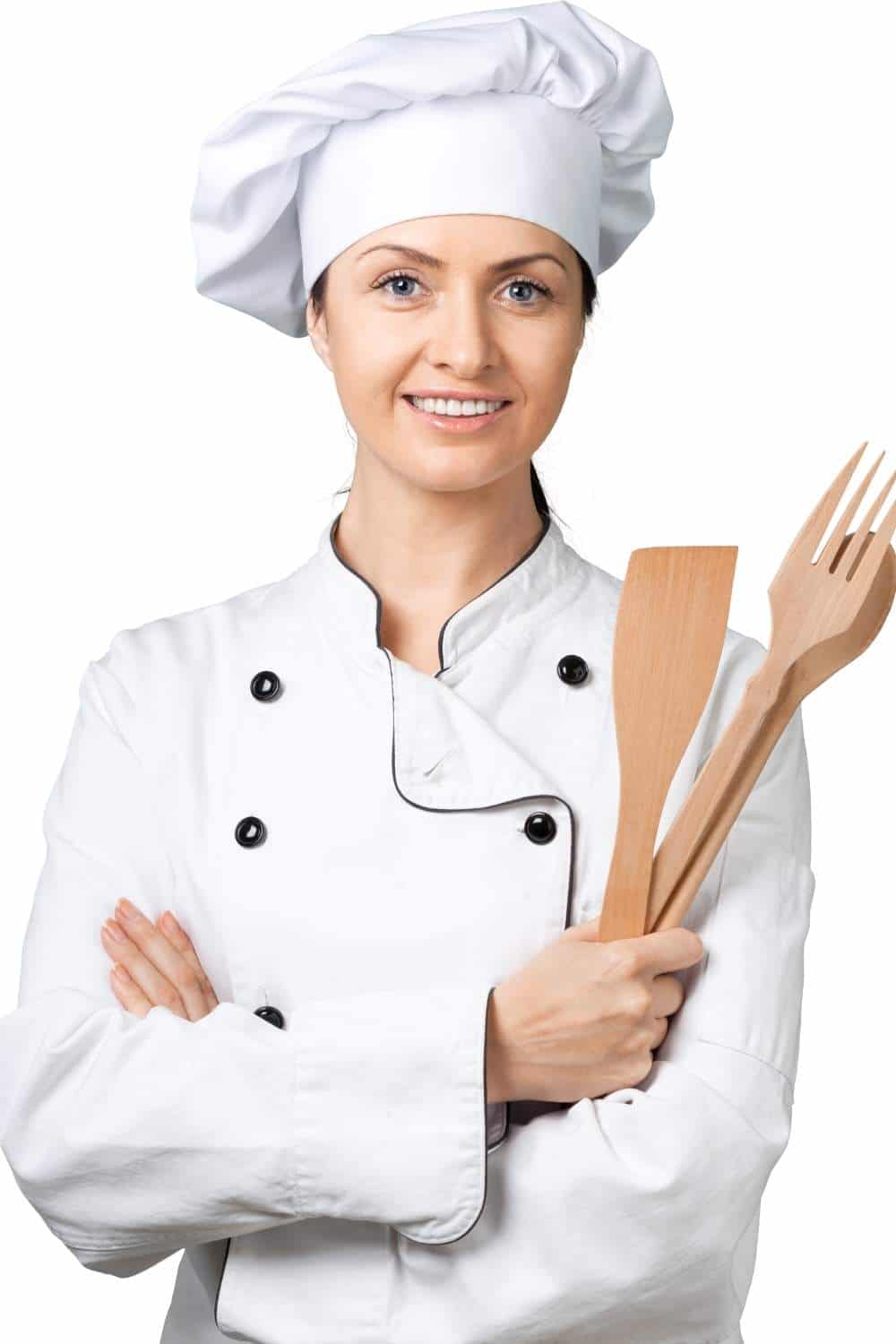 Woman wears chef hat and white coat, while holding wooden utensils.