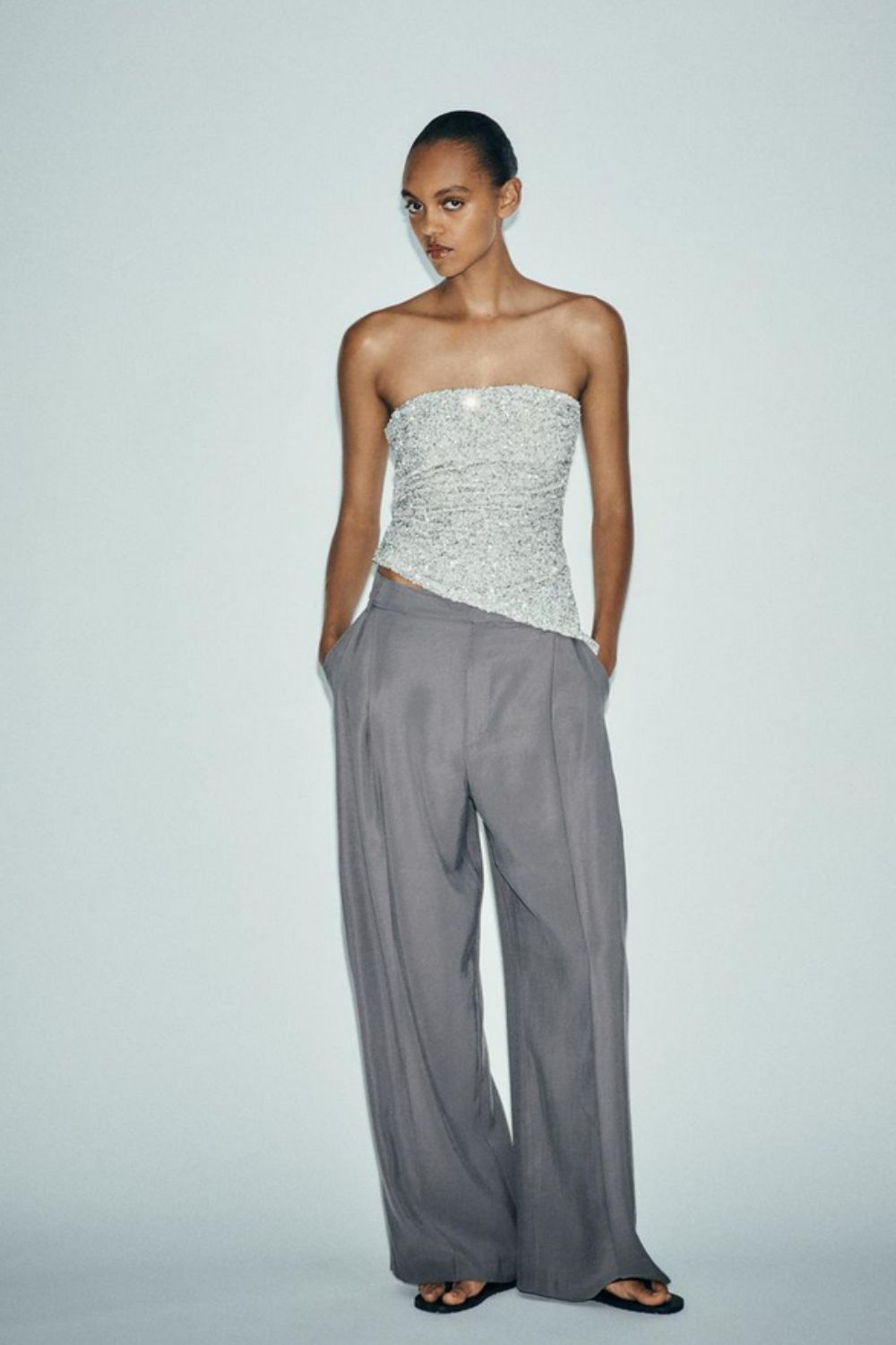 Model wears sequin top from Zara with wide-leg pants