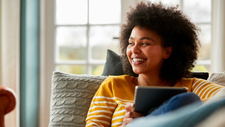 Person shops Amazon Prime Early Access Sale at home on couch.