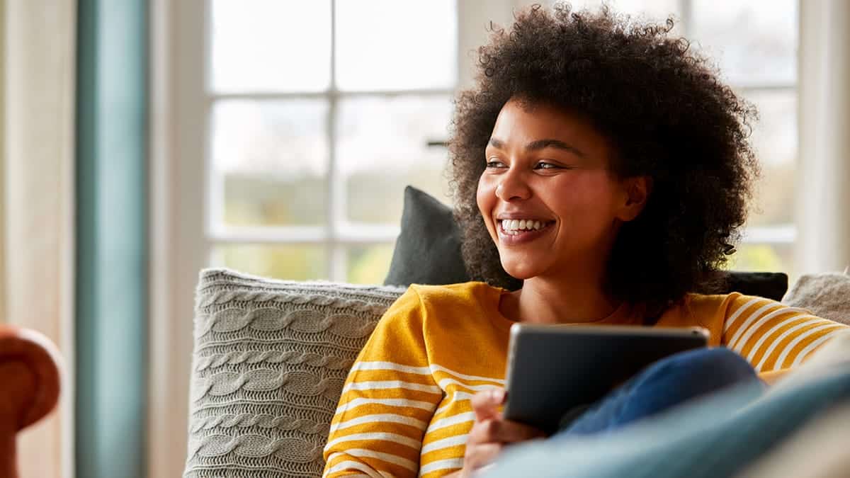 Person shops Amazon Prime Early Access Sale at home on couch.