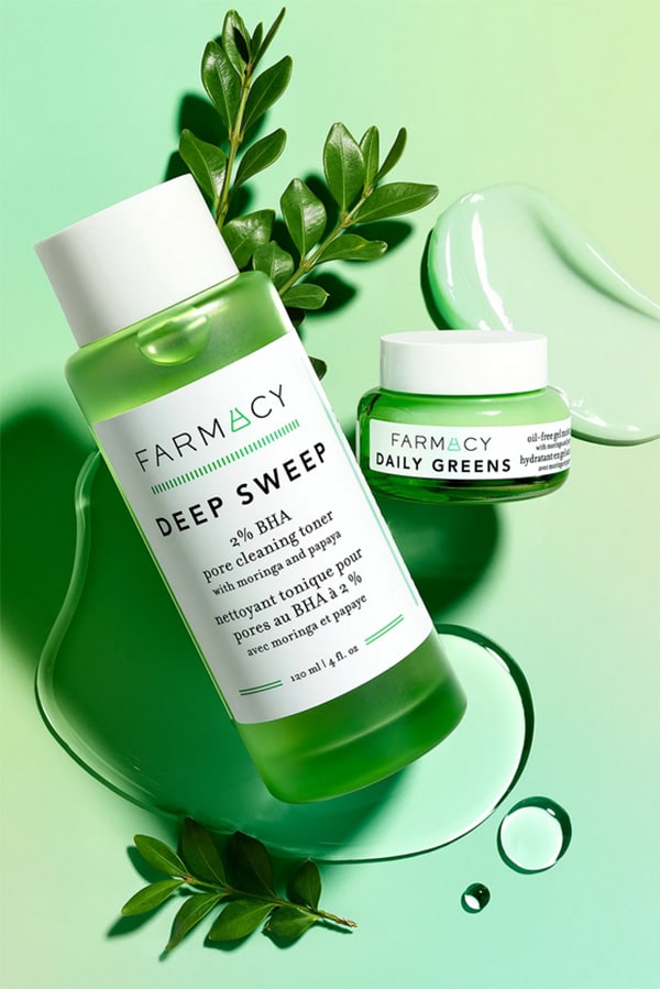 Farmacy beauty products Deep Sweep and Daily Greens against green background.