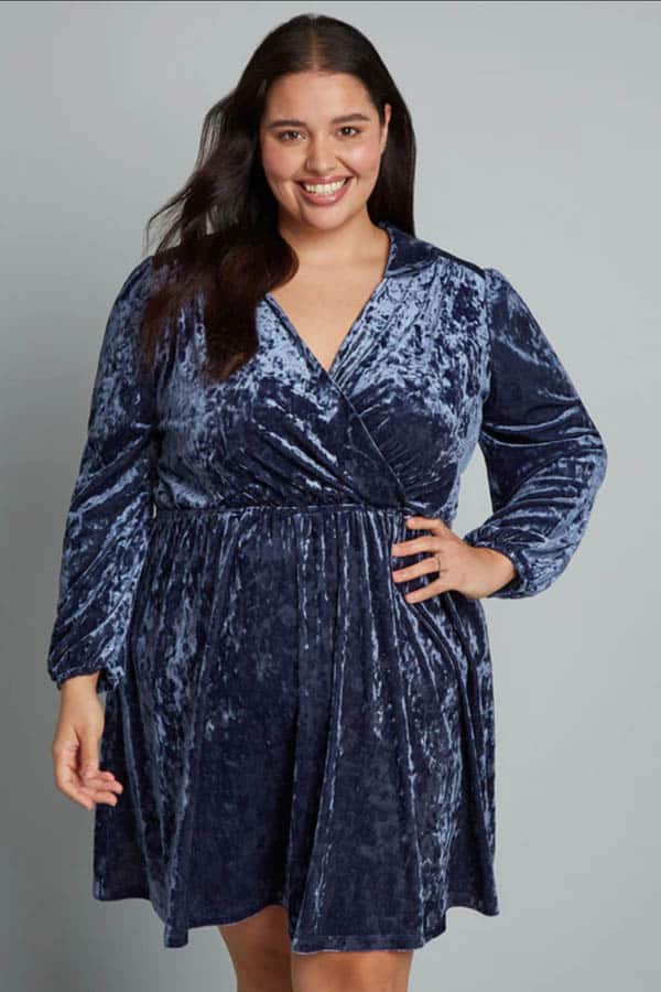 Model wears crushed blue velvet dress from online store Modcloth.