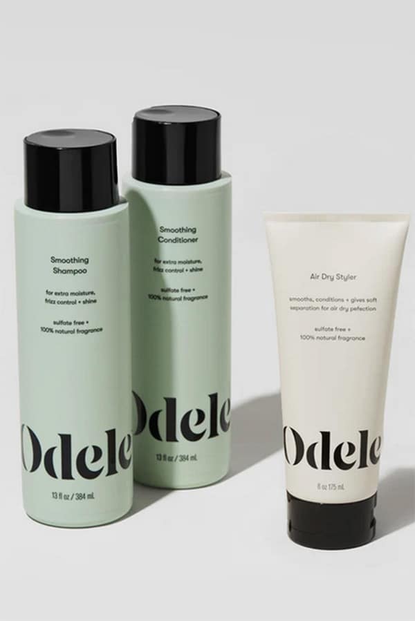 Product shot of Odele hair care set including shampoo, conditioner, and styler. 