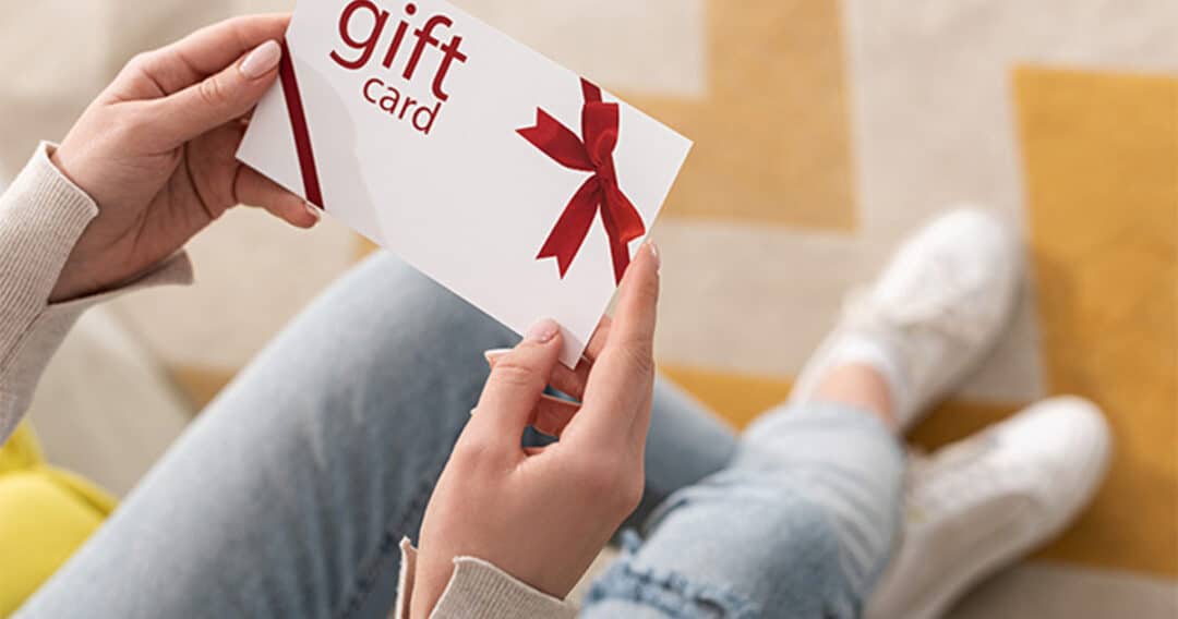 Girl holding blank gift card.