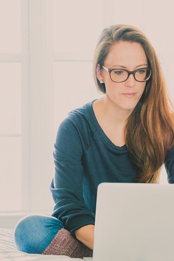 Woman works on laptop computer at home.