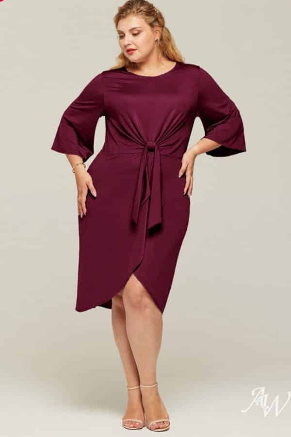 Model wears knee-length dress that ties in the front.