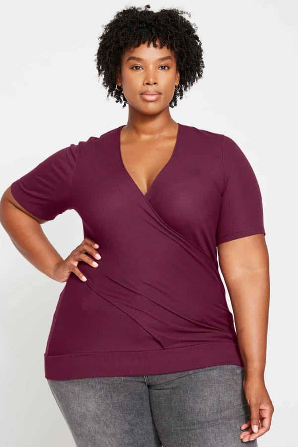 Model wears wrap top from plus-size clothing store Universal Standard.