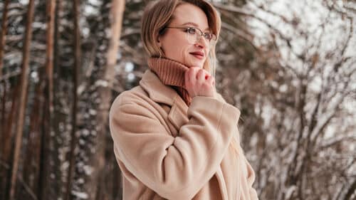 Woman dressed in brown coat and brown sweater, showing stylish winter outfits for women over 40.