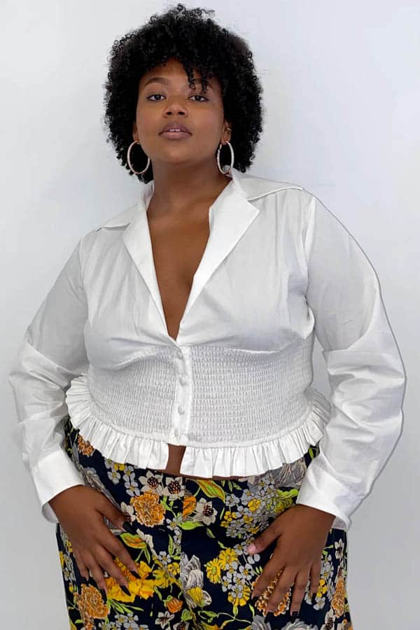 Model wears white button-down top from plus-size clothing store Wray NYC.