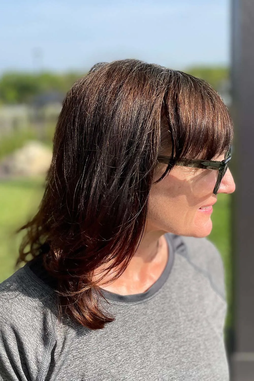 Seitenansicht von Catherine Brock mit Sonnenbrille draußen.