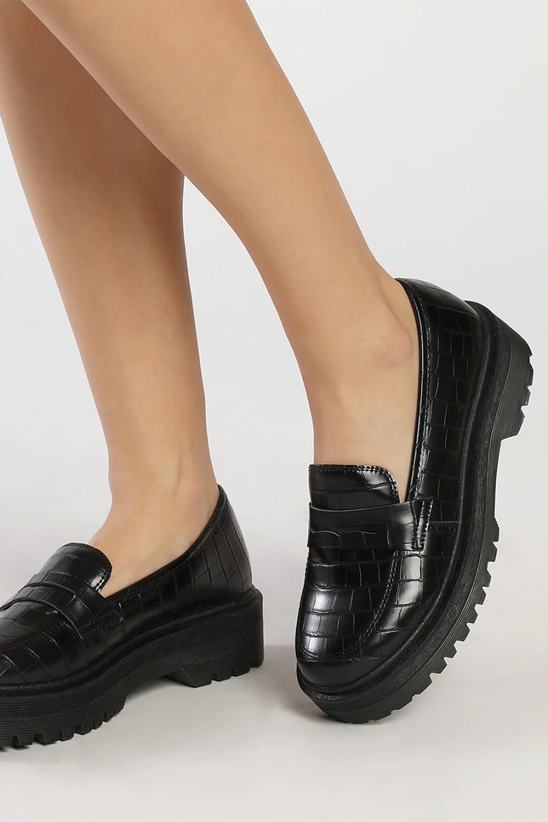 5 Trendy & Budget-friendly Chunky Loafers for Women 2 Close-up of woman's legs wearing crocodile embossed loafers.