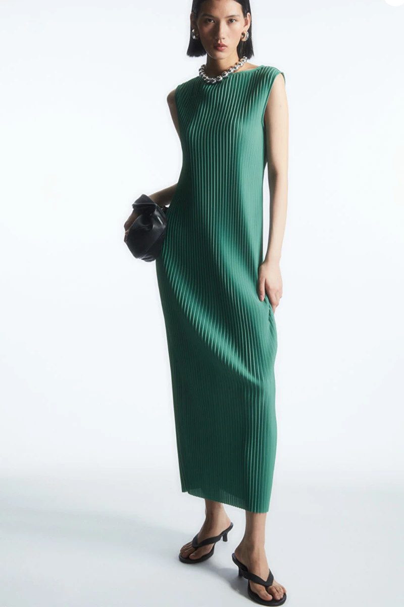 Model wears green maxi dress from midrange fashion store COS.