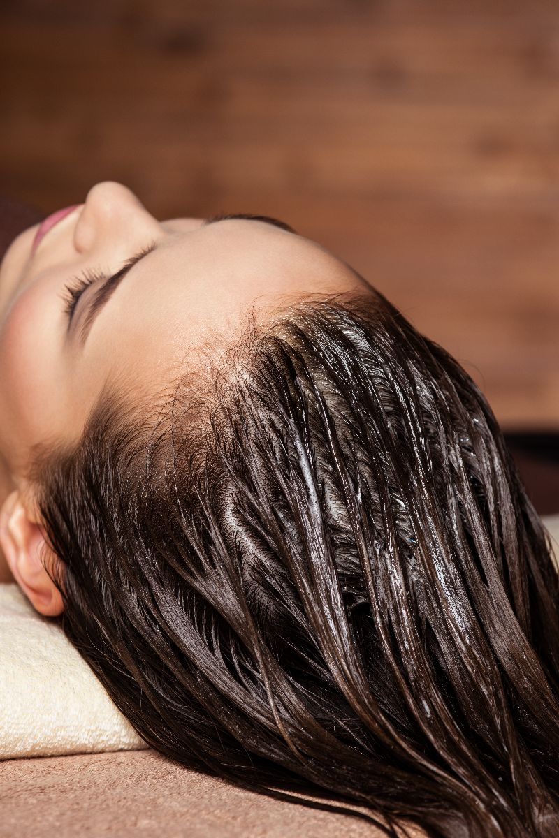 Woman lying down with treatment in her hair.
