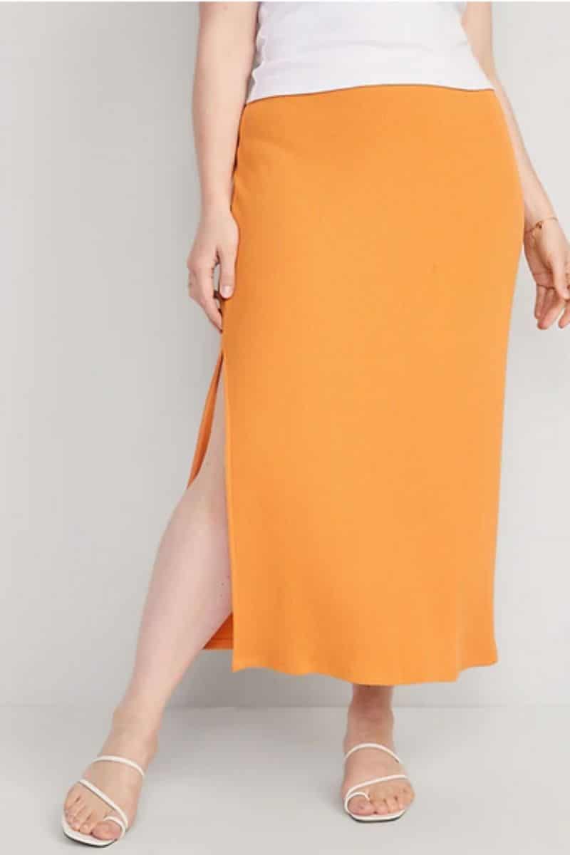 Waist-down view of woman wearing orange skirt, part of the Old Navy summer clothes collection.