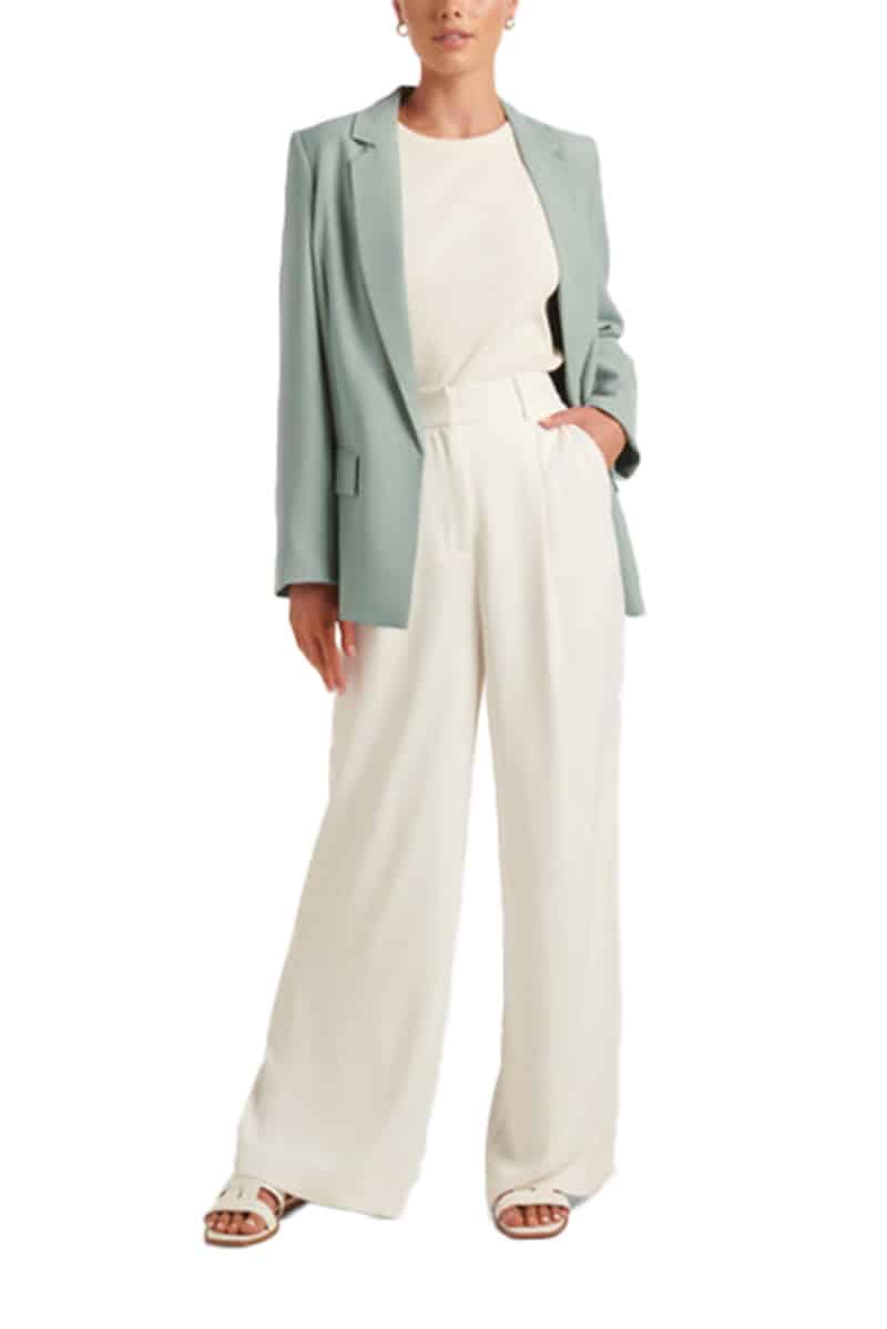 Sage green blazer paired with cream top and wide-legged pants.